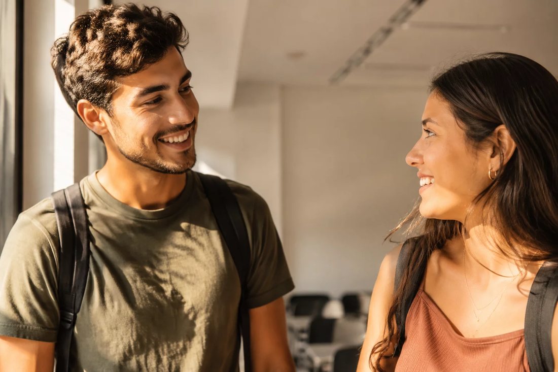 Dois estudantes de mochila continuam a discussão no corredor depois da sessão